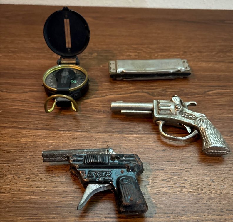 Items Including Cap Guns, Harmonica, and Compass