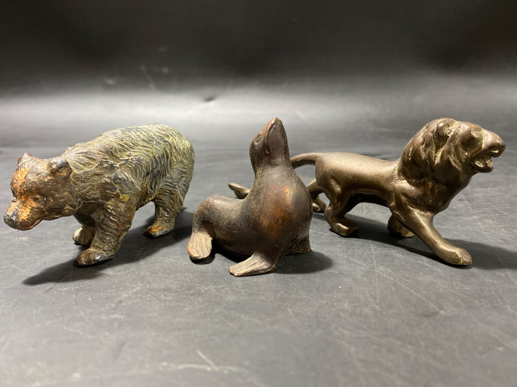 Three Cast Metal Animal Figurines: Bear, Seal, and Lion