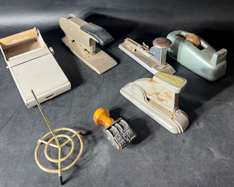 Vintage Office Desk Accessories Featuring Staplers, Tape Dispenser, and Date Stamp
