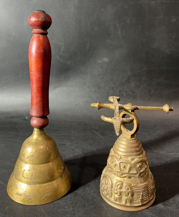 Two Decorative Brass Bells with Carved Designs and Wooden Handle