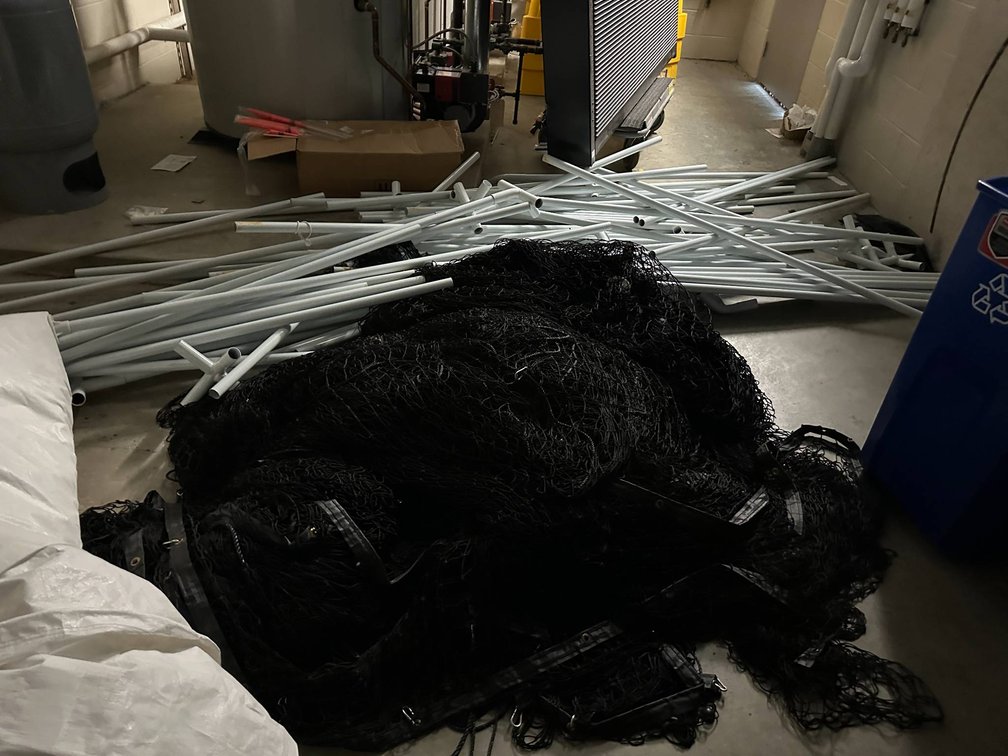 Bundle of Black Netting and Assorted White Metal Poles