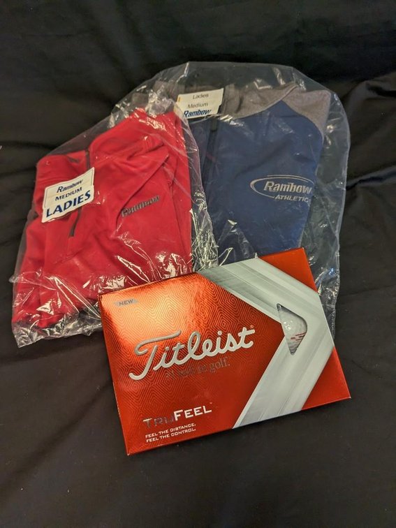 RAMBOW GOLF PACKAGE. 1 DOZEN TITLEIST GOLF BALLS. HOLLOWAY LADIES MEDIUM HOODED JACKET. BADGER SPORT LADIES MEDIUM QUARTER ZIP JACKET.