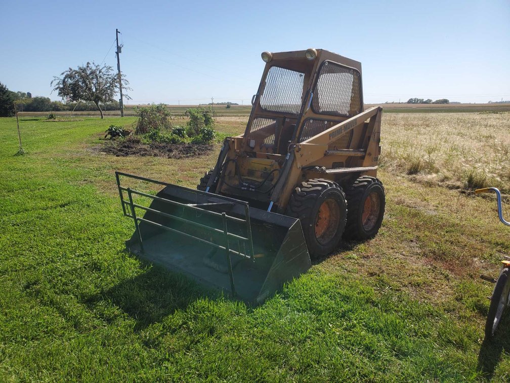 PRIME MOVER L-1200 SKID LOADER, 4 CYL GAS ENGINE, 6' BUCKET, 3466 HRS SHOWN, AUX HYD, RUNS AND OPERA