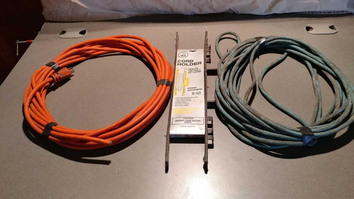 (1) BLUE EXTENSION CORD AND (1) ORANGE EXTENSION CORD (NEEDS REPAIR ON ONE END)