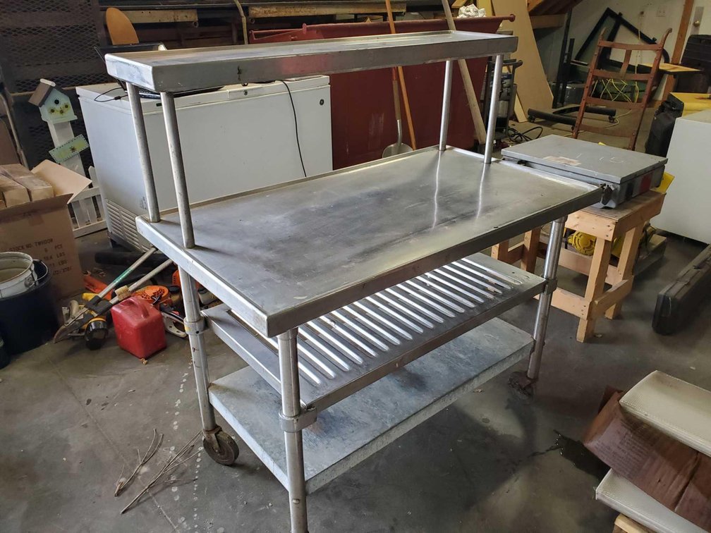 (I-16) STAINLESS STEEL MULTI TIER TABLE ON WHEELS, 48" X 26" (FOR MORE INFO AND LOCATION CALL NEIL @