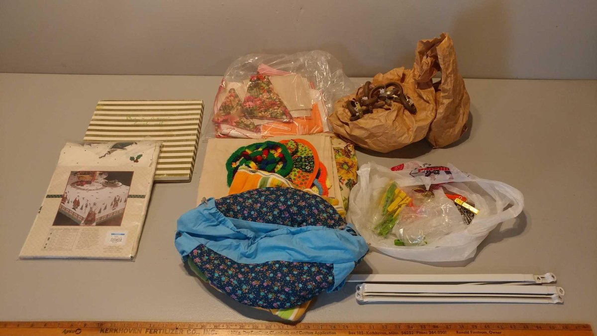 ASSORTMENT OF TABLE CLOTHS, CASSEROLE TAKER, CURTAIN RODS, & MISC CURTAIN HOLDERS & CLOTHES PINS