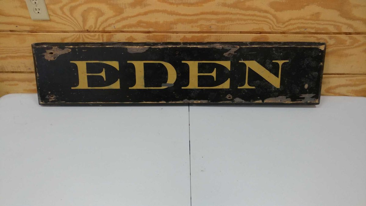 WOODEN SIGN WITH WHITE LETTERS READING "EDEN" FROM THE RAILROAD. THIS IS MOST LIKELY RELATED TO EDEN