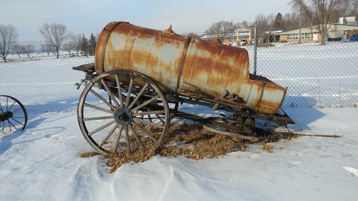 WATER TANK WAGON FOR TRANSPORTING WATER TO STEAM ENGINES. IT HAS WOODEN WHEELS AND A METAL TANK.