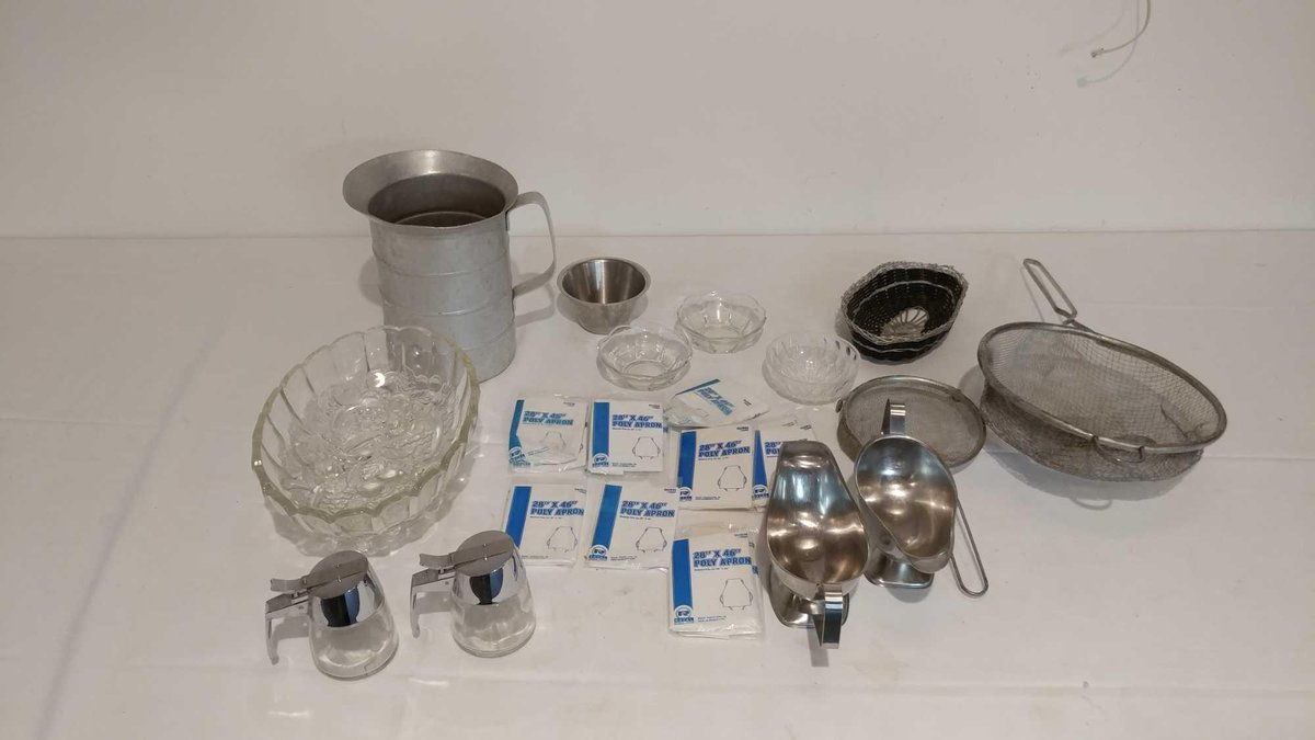 ASSORTMENT OF GRAVY BOATS, SUGAR HOLDERS, METAL WIRE STRAINERS, DECORATIVE GLASSWARE AND APRONS