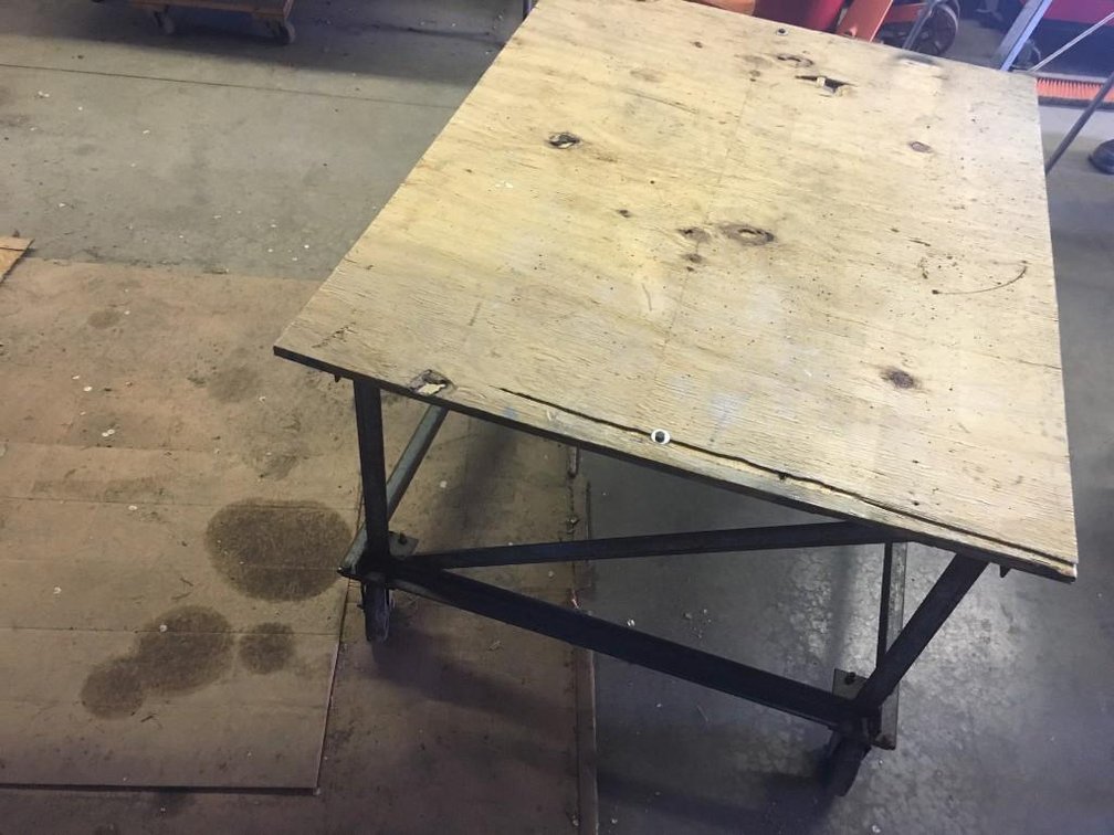 (I-202) ROLLING TABLE ON WHEELS, 1/2 IN PLY WOOD TOP, 48"X36" 5" WHEELS, 27IN TALL, (LOCATED SOUTH O