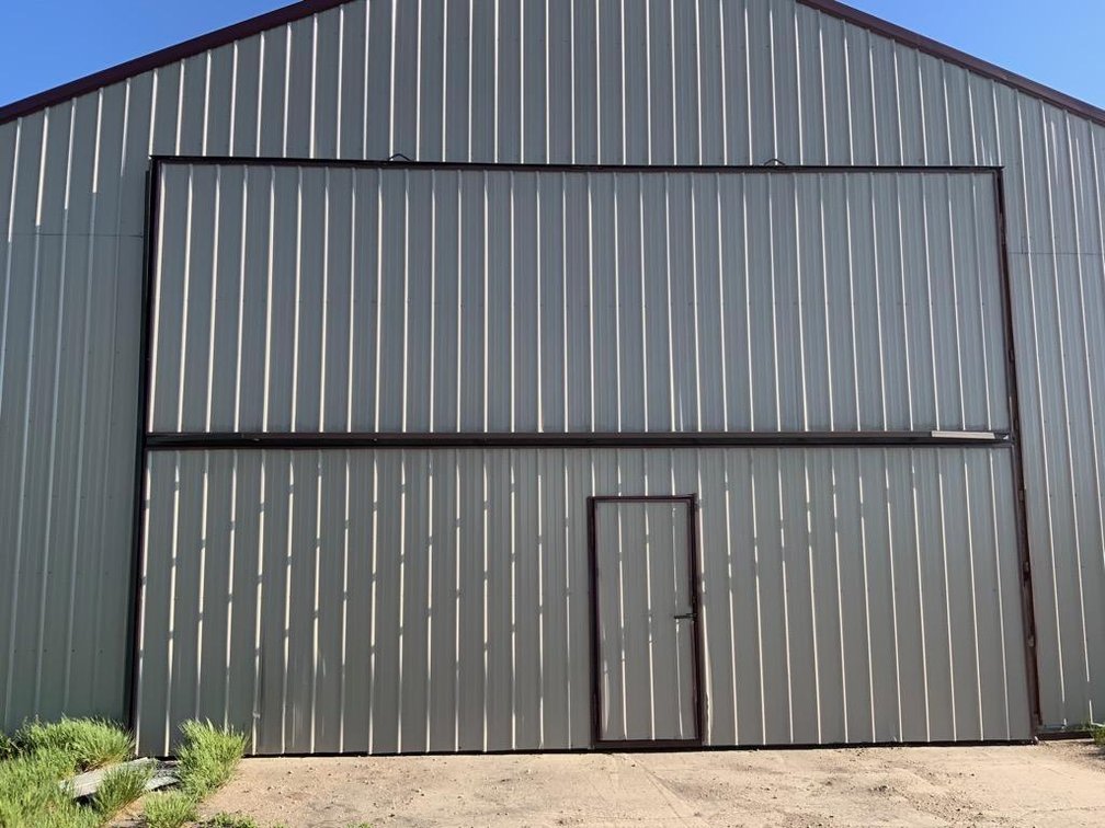 (I-231) HOMEMADE BI-FOLD DOOR 24' 2" WIDE X 16' 5" HIGH, HAS WINCH AND ELECTRIC MOTOR INCLUDED IS TA