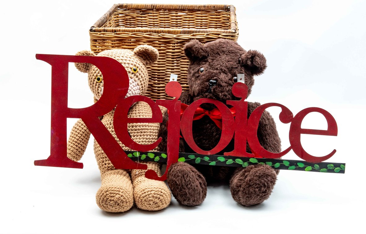 Teddy Bears in Toy Basket with "Rejoice" Sign