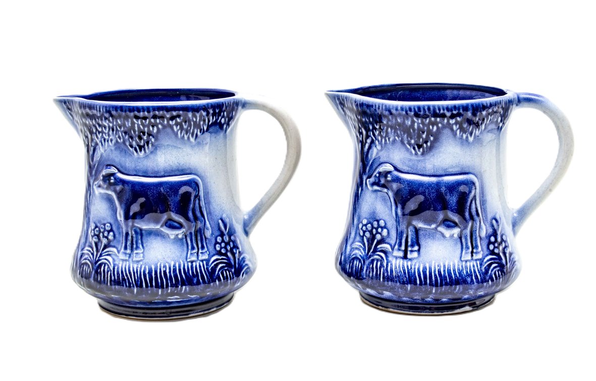 Pair of Vintage Flow Blue Cow Relief Pitchers