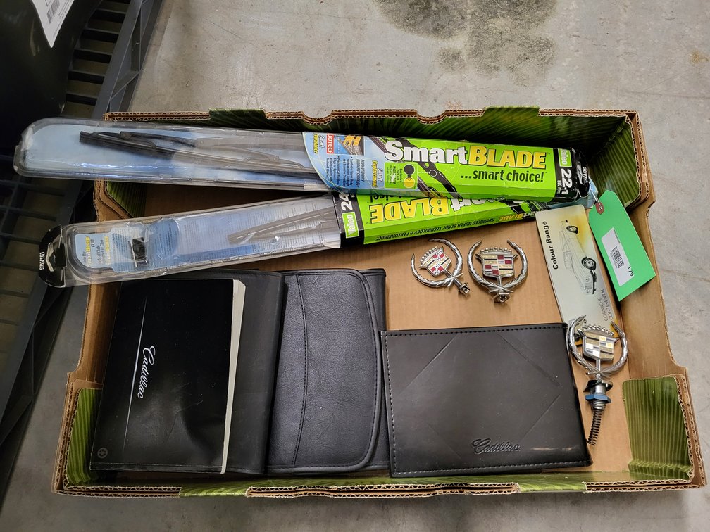 (3) Cadillac hood ornaments, Deville manuals, and wiper blades