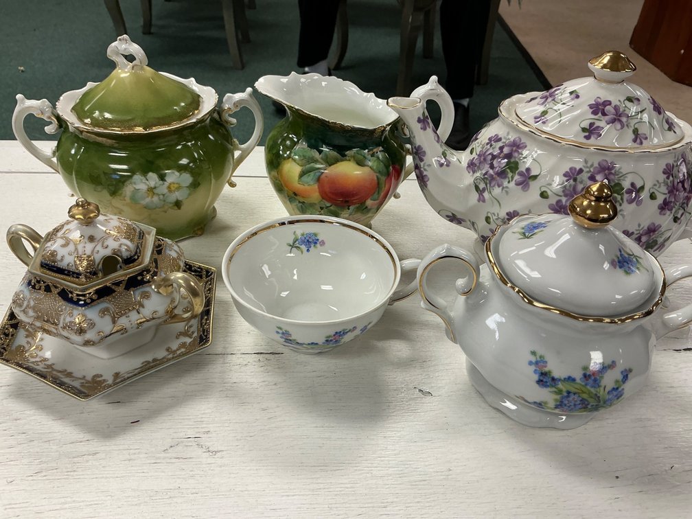 Collection of Six Porcelain Teapots and Teacups with Various Floral and Fruit Motifs