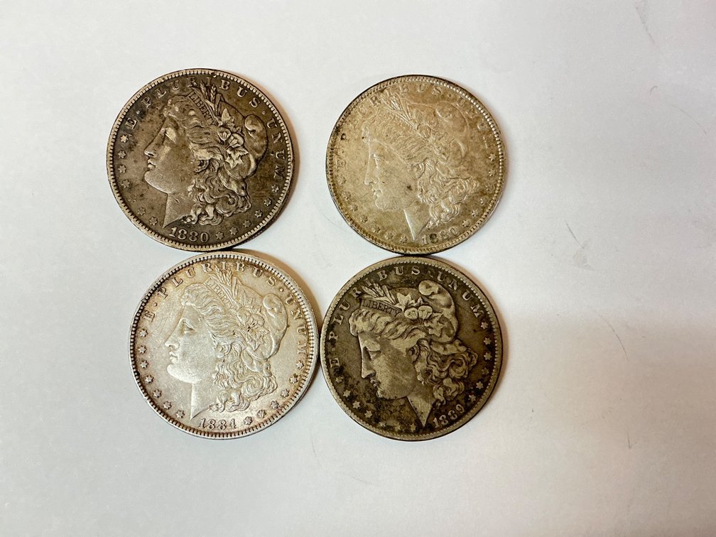 Four Morgan Silver Dollars: 1880O, 1880, 1884, and 1889
