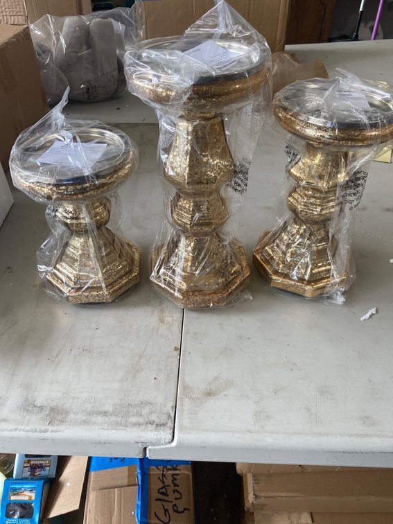 Three Gold-Toned Pillar Candle Holders in Varying Sizes