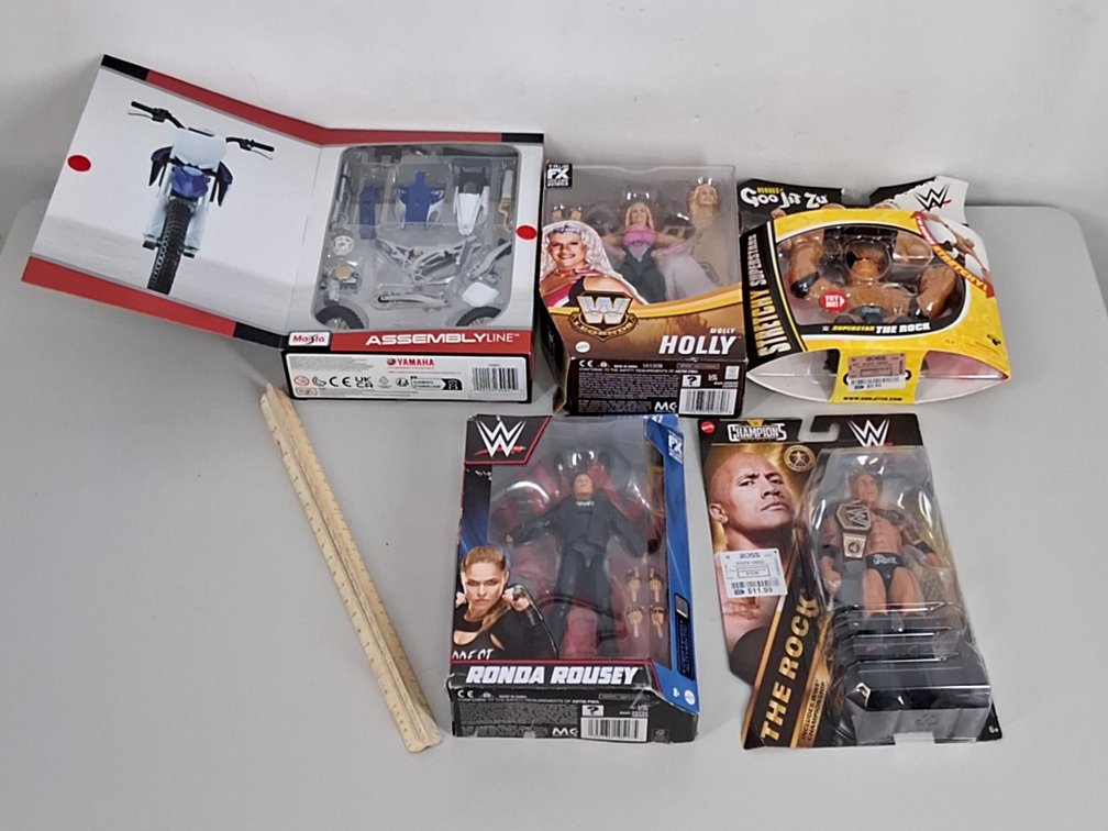 4 WWE action figures in boxes and a Yamaha dirt