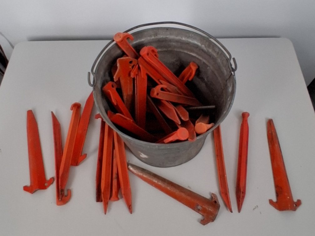 galvanized bucket of tent stakes
