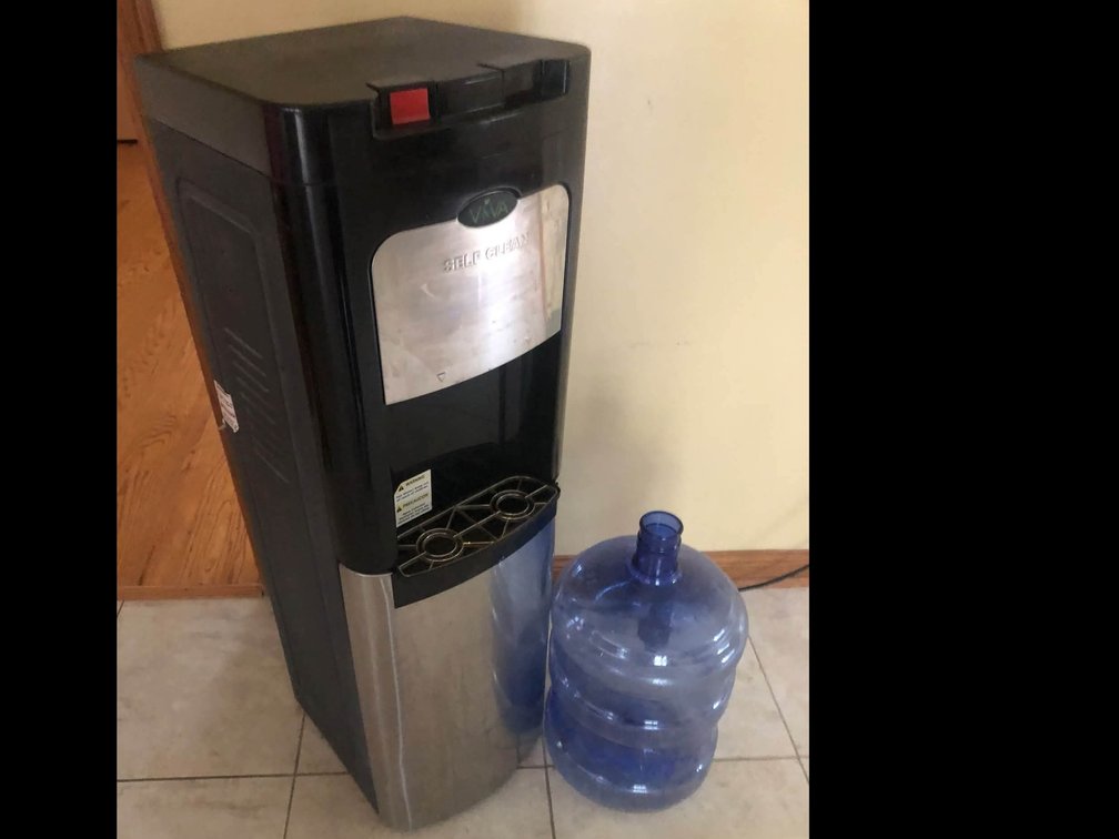 Self cleaning bottom loading water dispenser