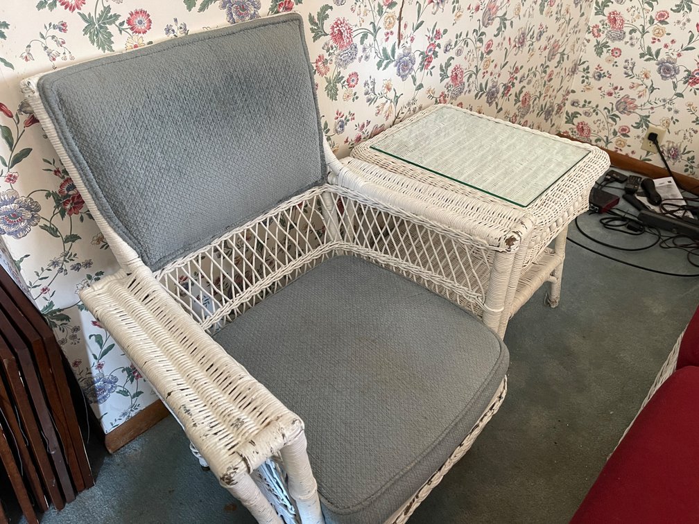 Wicker Chair and side table.  Chair has blue cushion.