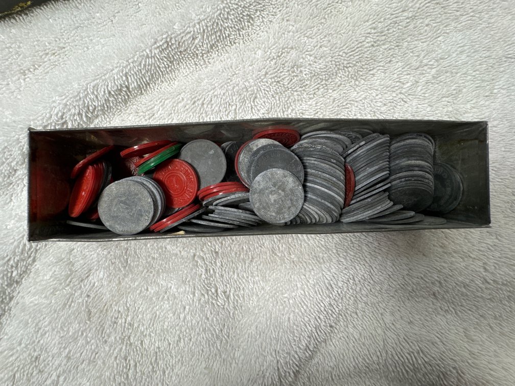 Tin box with zinc tax mills and red and green plastic tax mills