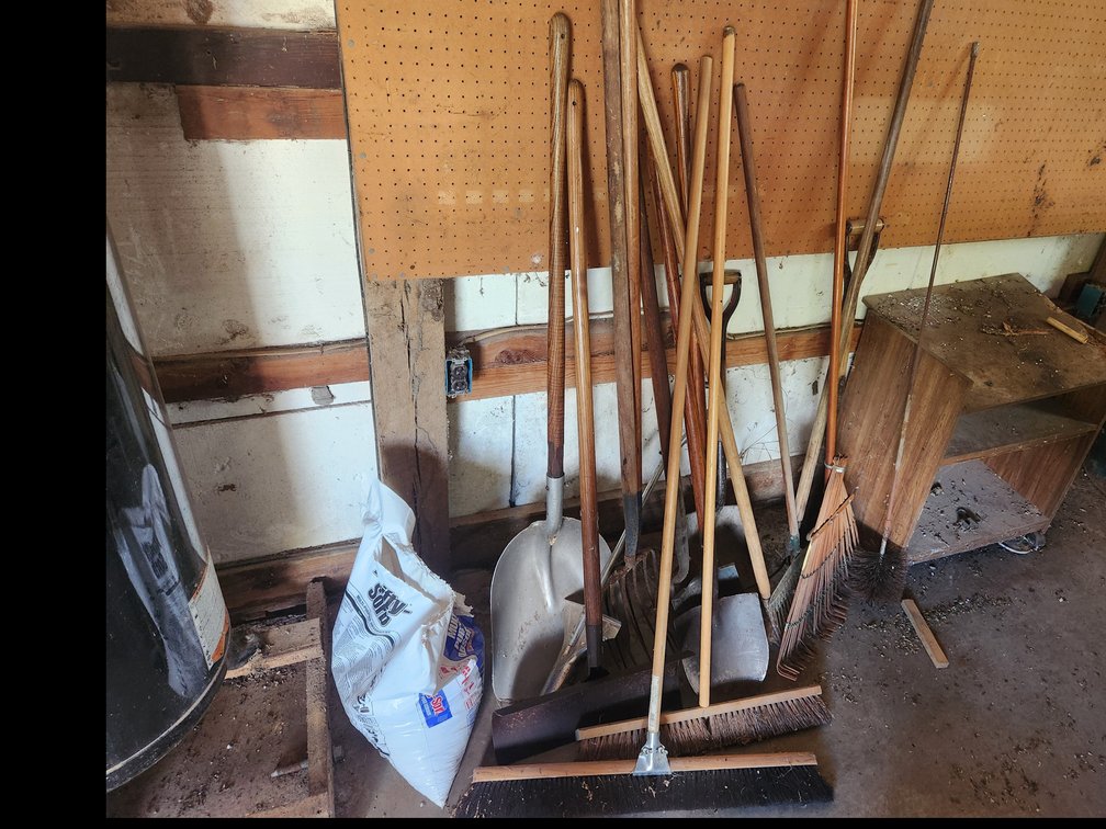lot of garden tools and brooms