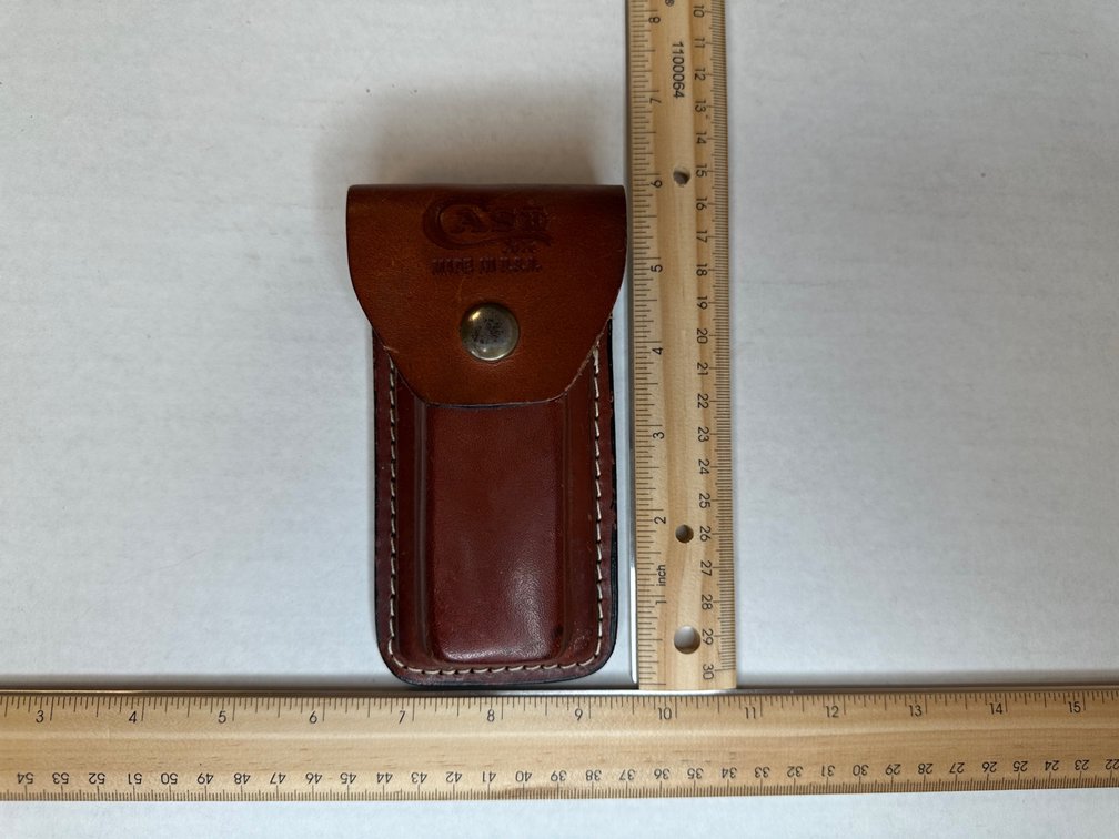 Case XX Changer Knife in leather belt snap case. Knife handle is wood grain finish.