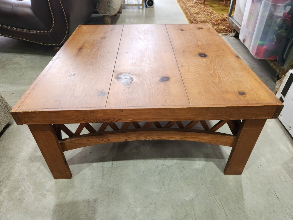 Square coffee table, arched design on sides.