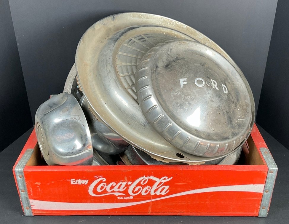 Assortment of Vintage Hubcaps in a Coca Cola Crate