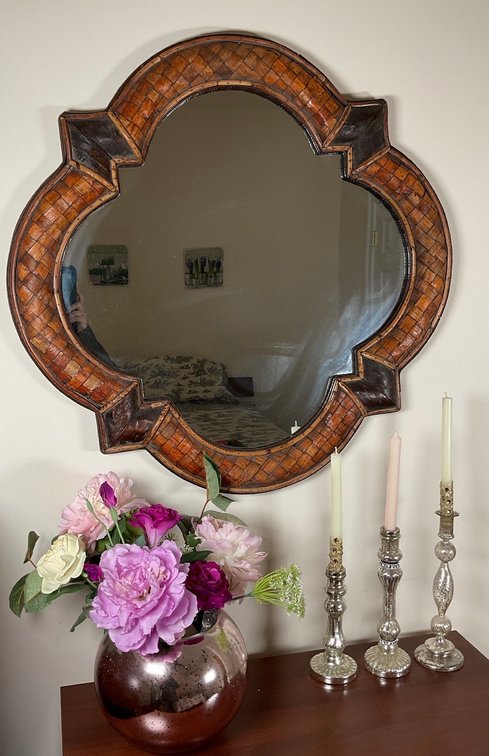 Woven Rattan Wall Mirror with Mercury Glass Candlesticks and Floral Arrangement