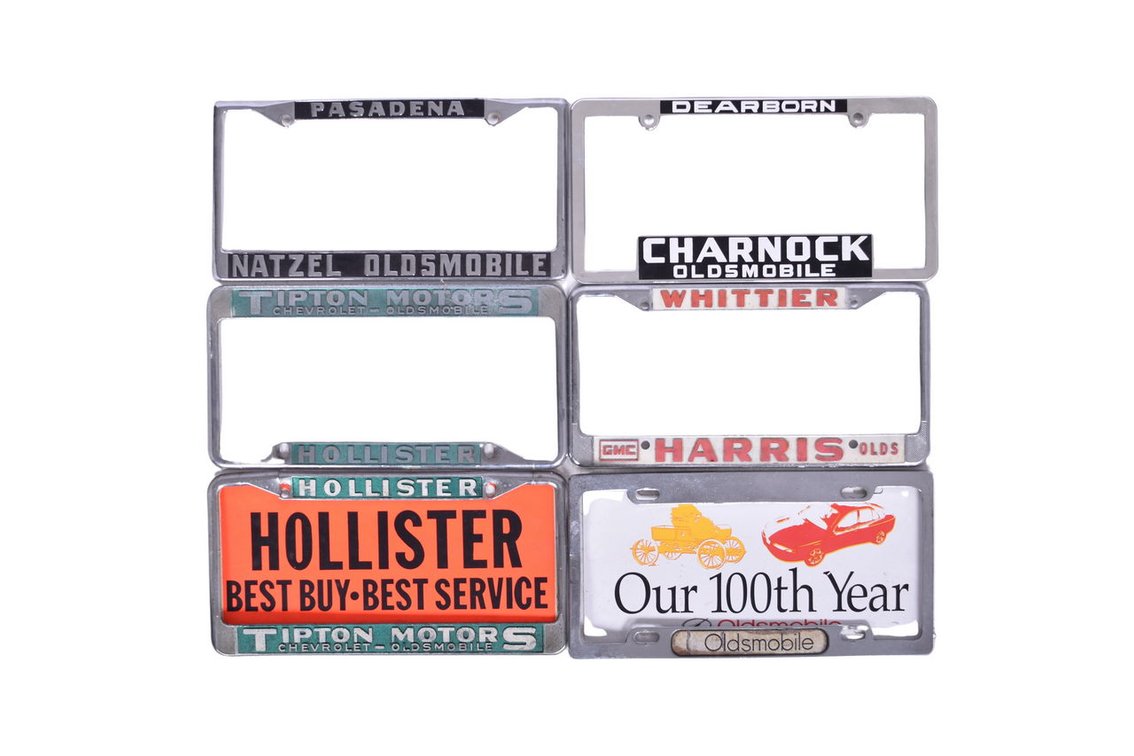 Six Oldsmobile Car Dealership Advertising License Plate Frames and Two Inserts