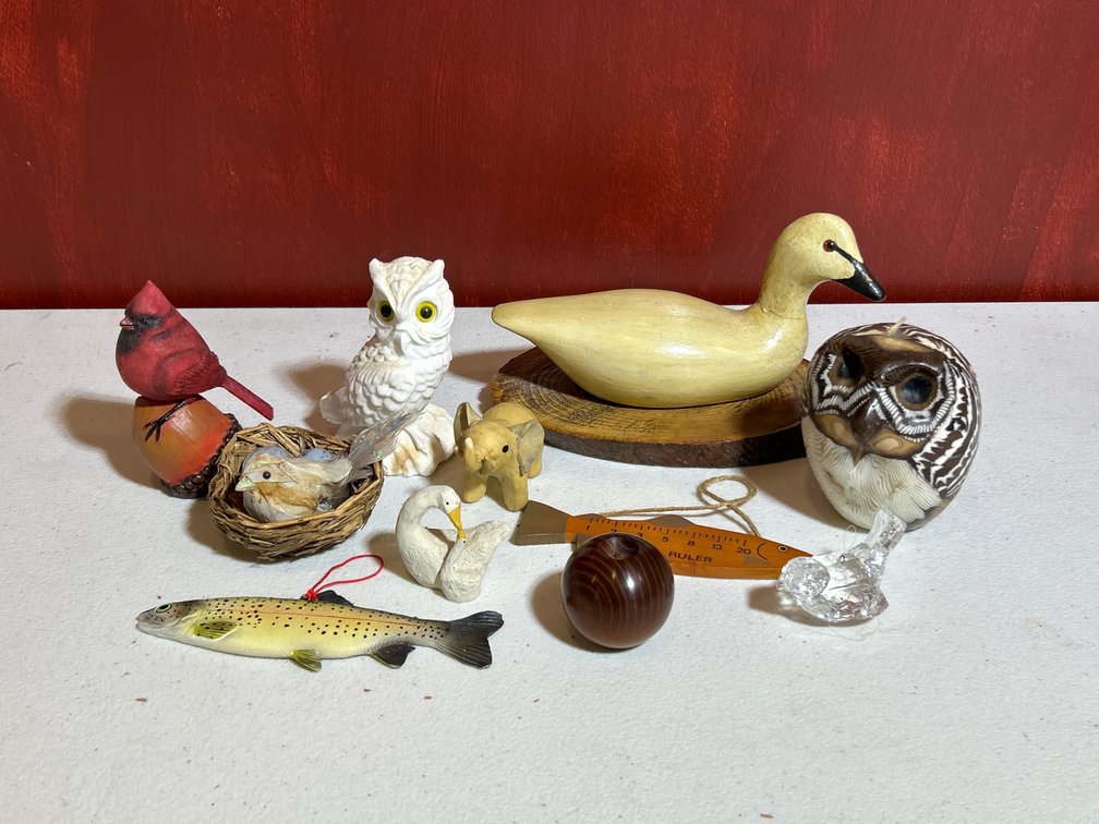 Assorted miniature wildlife figurines, bird carvings, and decorative knick-knacks