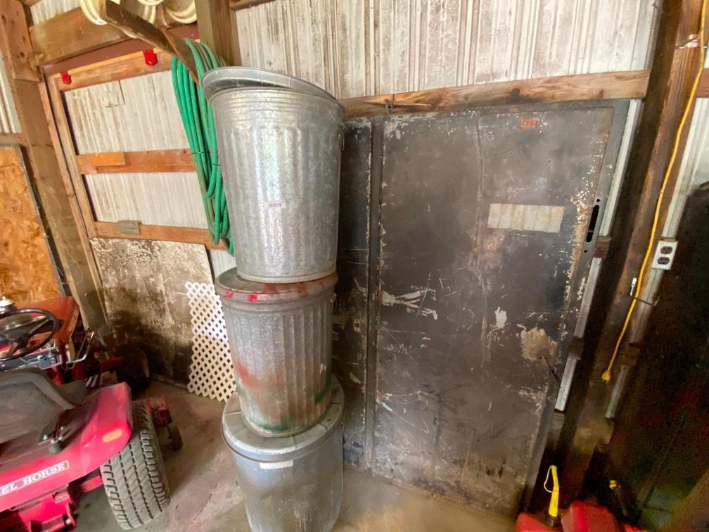 Metal cabinet, garden hose and 3 trash cans