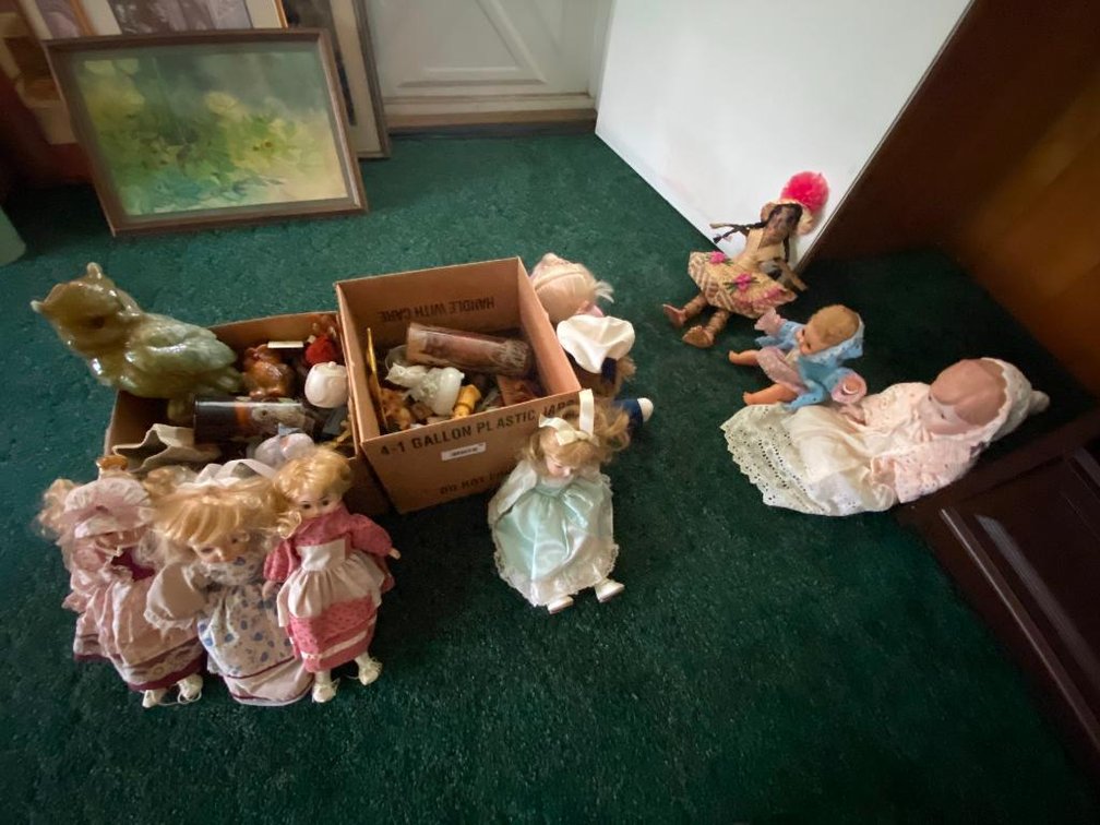 two boxes of figurines and dolls on the floor