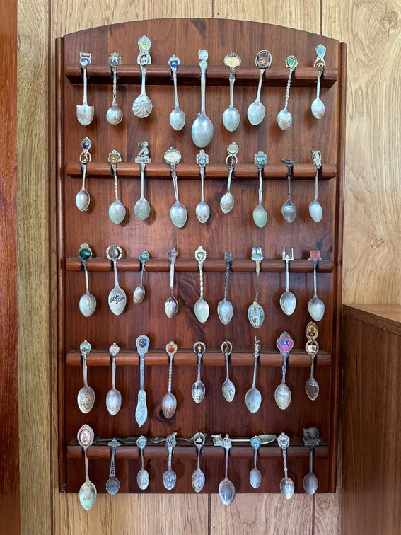 Large Collection of Souvenir Spoons on Rack