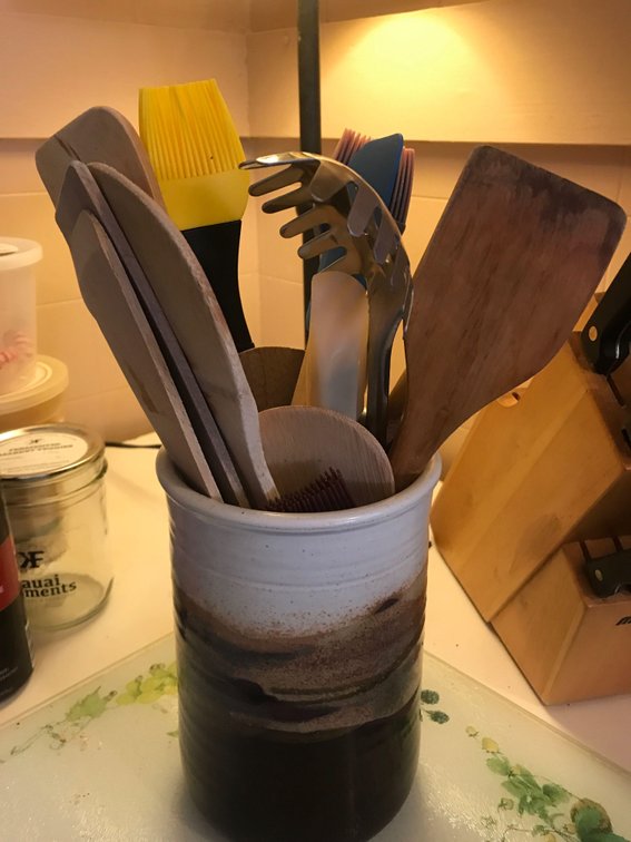 mixed wooden utensils , basters ,with ceramic utensile caddy