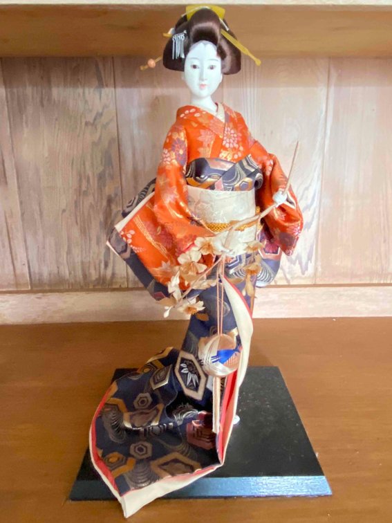 Japanese Geisha Doll In Orange Colored Kimono on Stand 
