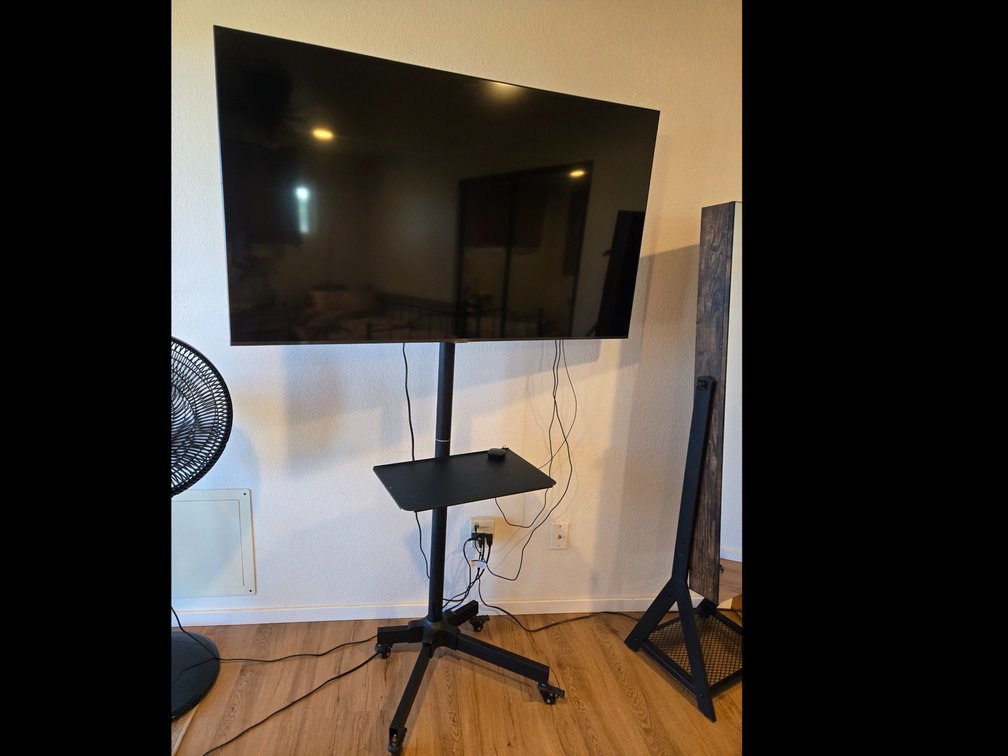 55" Samsung Smart TV with Wheeled Stand, Tray, and Remote.