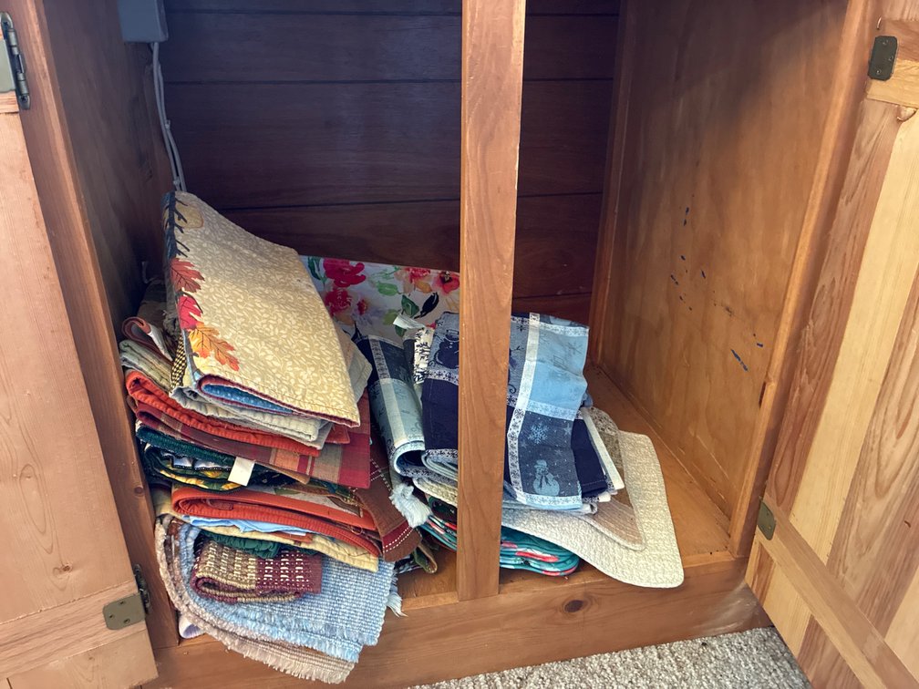 Assorted Placemats, Napkins And Table Runners in Bottom Cabinet