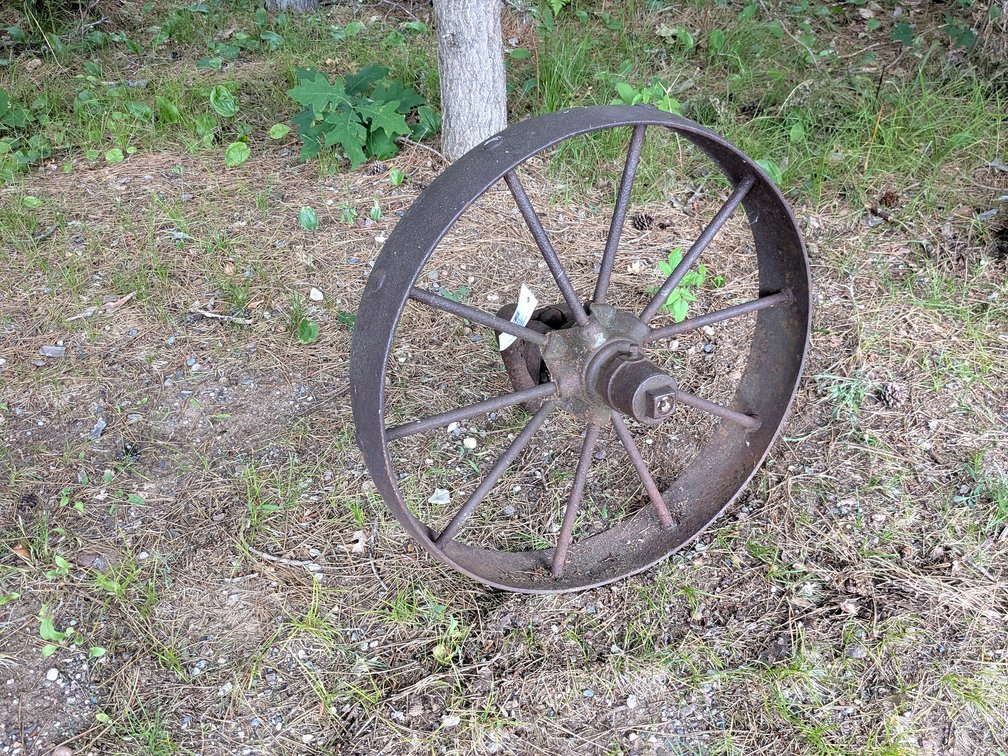 Wrought iron implement wheel is 2' across.