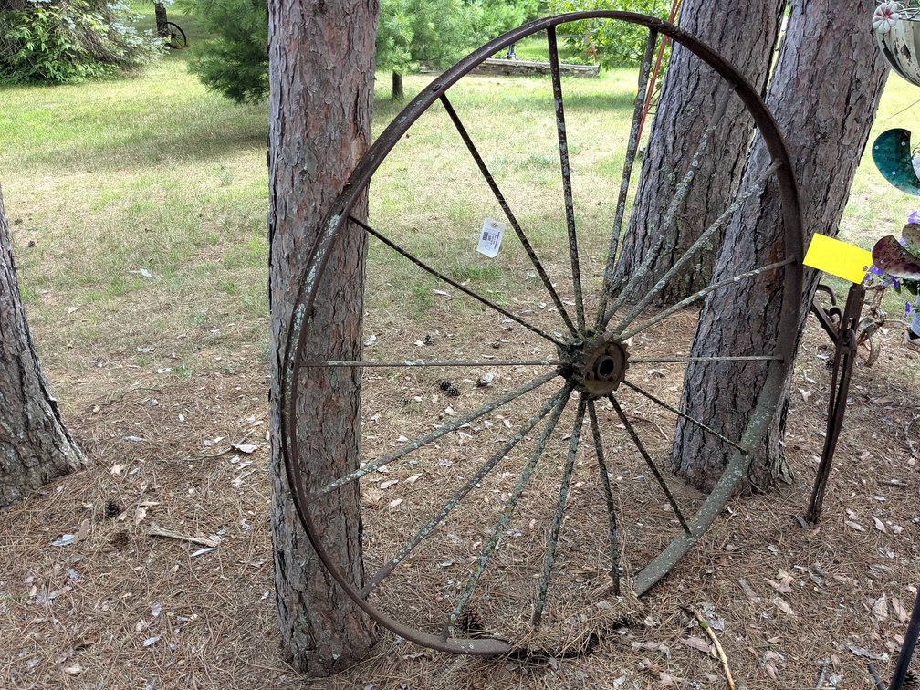 Antique steel wheel is about 54" wide.  Another in lot 1503.