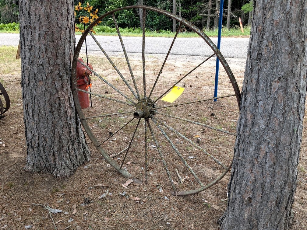 Antique steel wheel is about 54" wide.  Another in lot 1500.