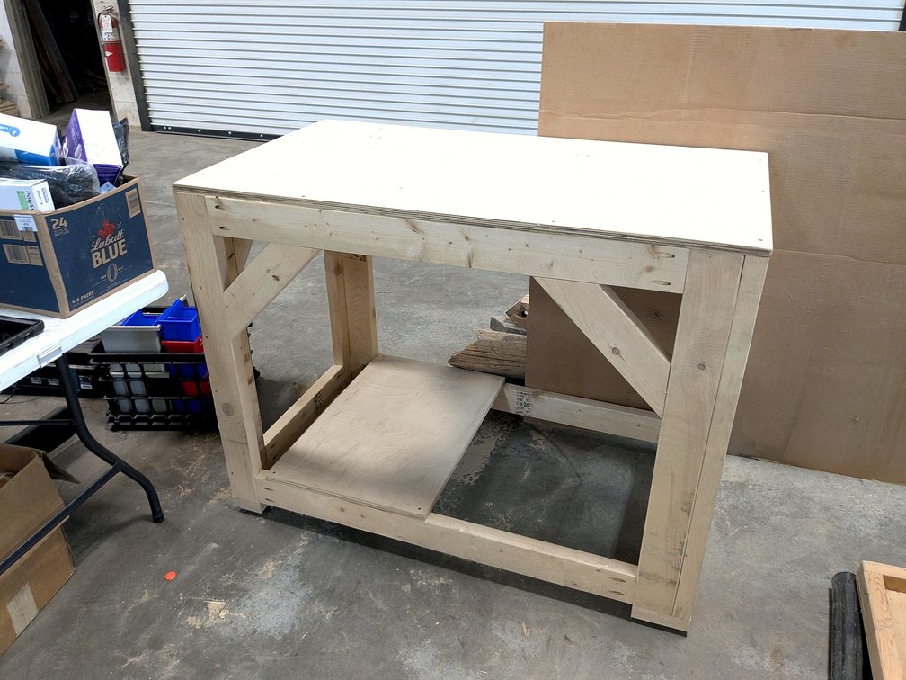 Sturdy wooden work bench is 4' x 27" x 37" high.