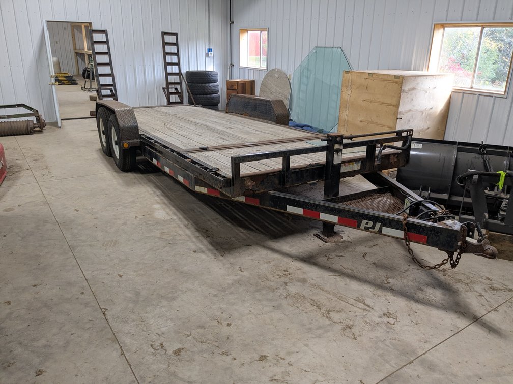 PJ tandem axle equipment trailer with 20' deck and ramps.