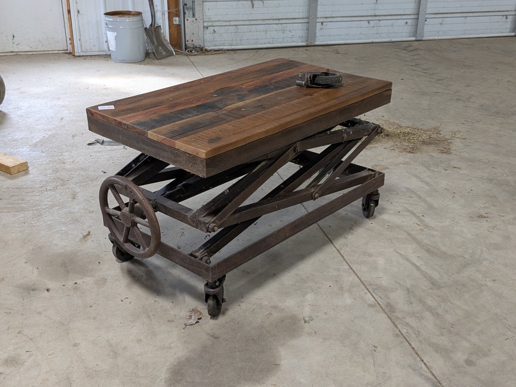 Industrial rustic coffee table measures about 3' x 20", height adjusts with hand wheel.  One caster