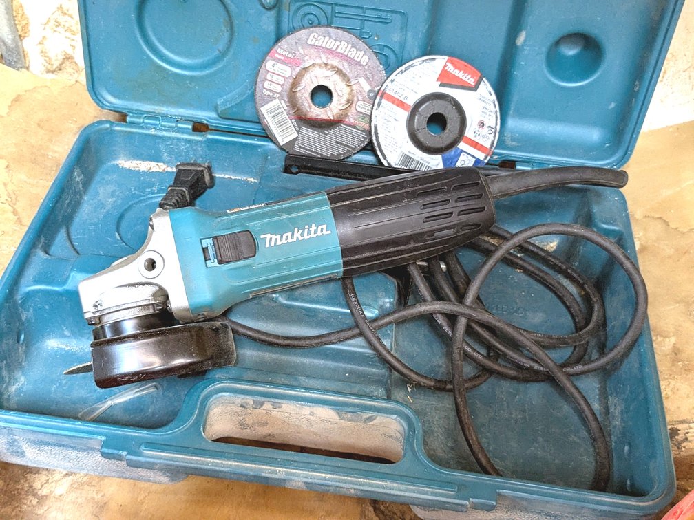 Makita 4" angle grinder with case and wheels.