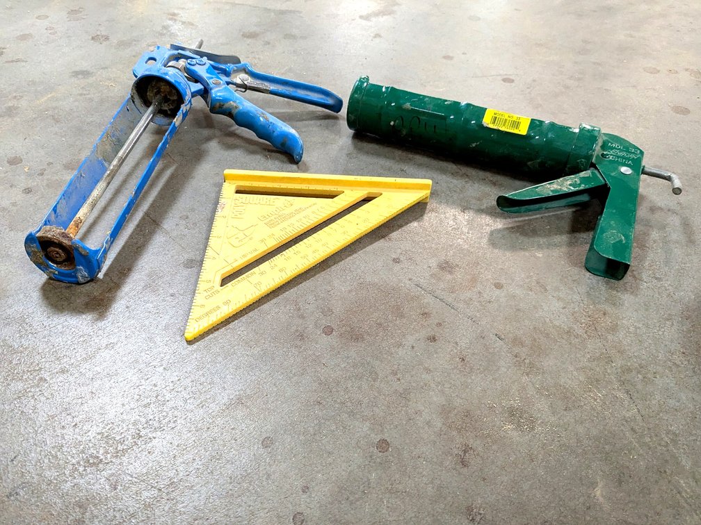 Two caulk guns and an Empire poly-square.