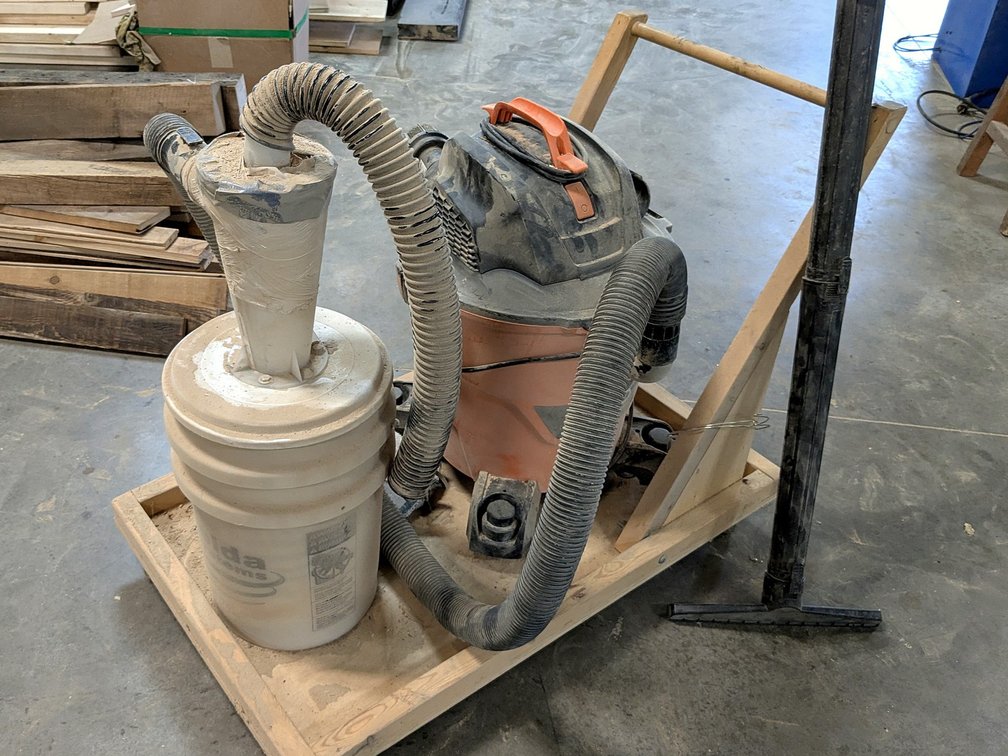 Ridgid shop vac dust collector system looks to be about 6 gallon.  Comes with rolling wooden cart, e