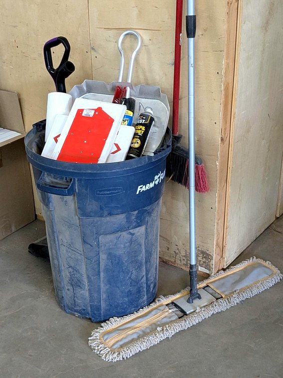 Rubbermaid garbage can with lid; brooms, dust pans, partial cans of Raid and more.